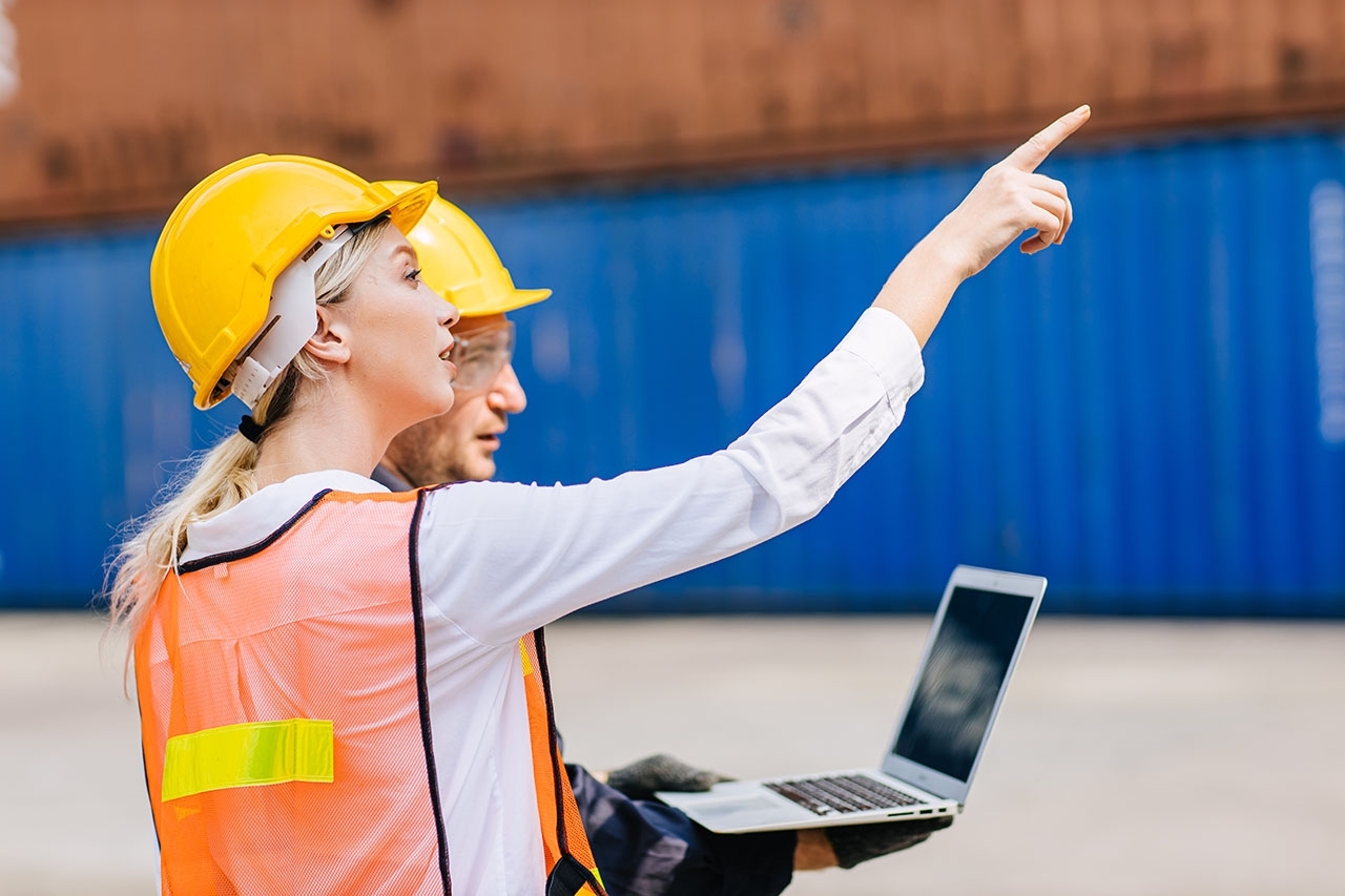 two people in yellow hard hats and orange safety vests
