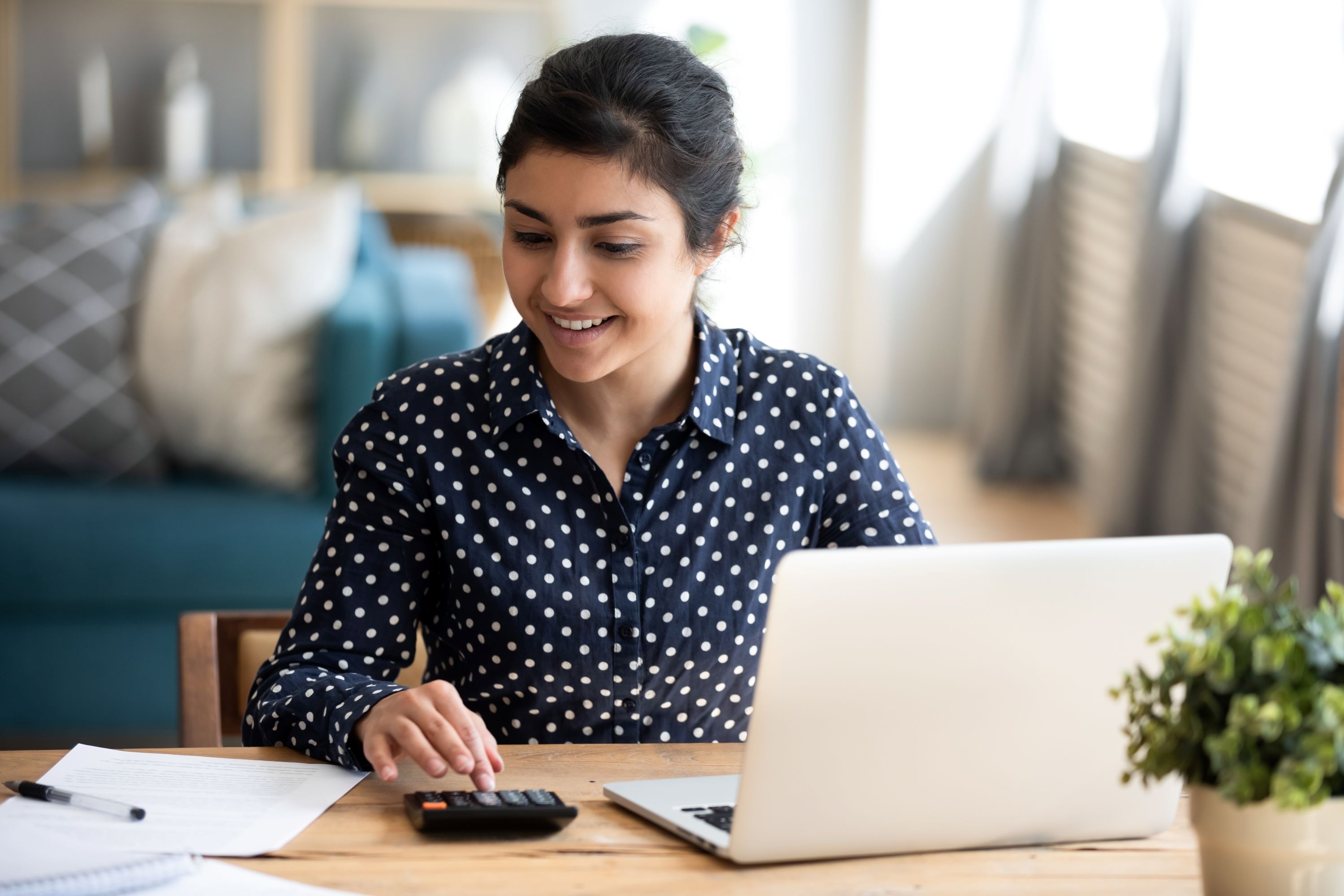 woman using a calculator and a laptop