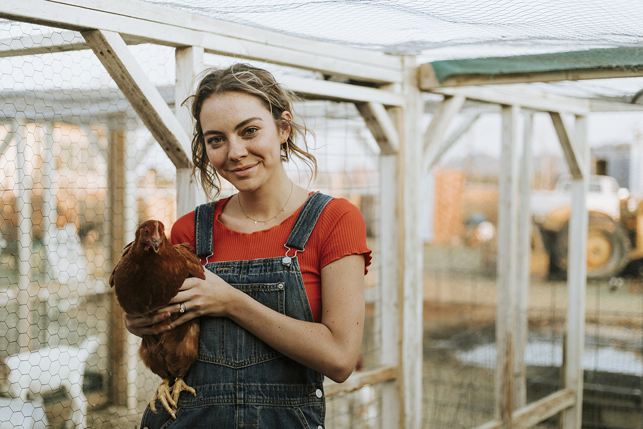 girl holding a brown chicken